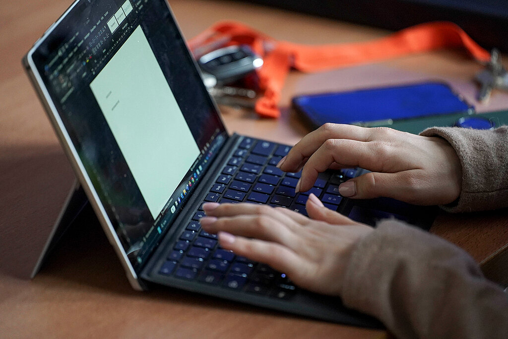 [Translate to Einfache Sprache:] Zwei Hände tippen auf der Tastatur eines Laptops.