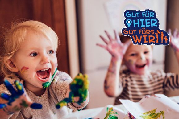 Zwei kleine Kinder spielen mit Farbe.