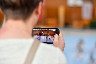 Ein Junge filmt mit seinem Handy.