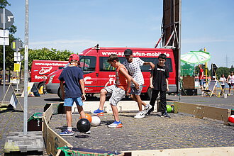Kinder spielen auf der Straße Fußball.