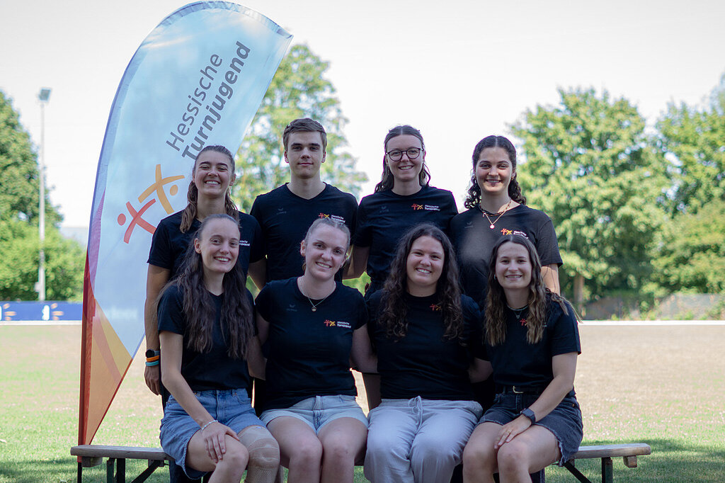 Acht junge Menschen posieren für ein Gruppenfoto