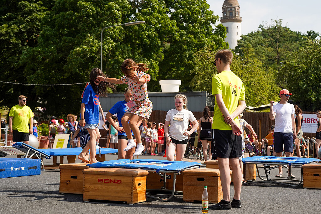 Ein Helfer unterstützt auf dem Turnfest ein Mitmachangebot.