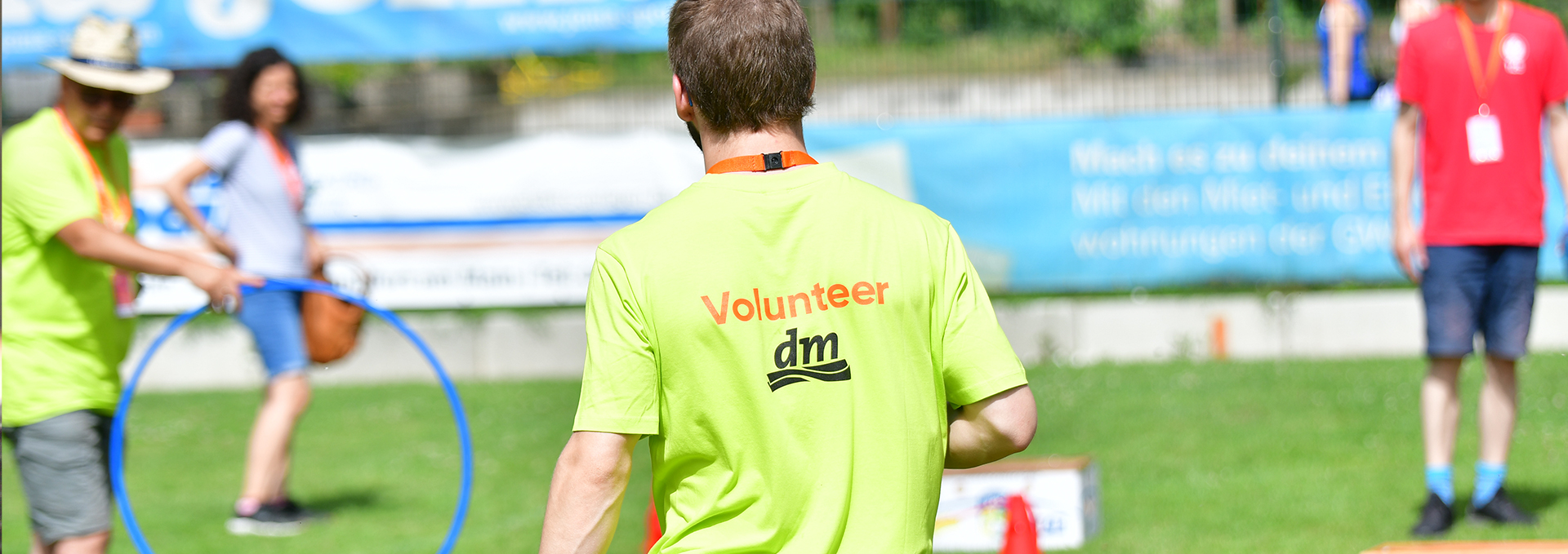 Ein Jugendlicher ist mit einem Volunteer T-Shirt von hinten zu sehen.
